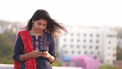 Schöne-Indische-Frau-In-Einem-Sari,-Der-Ihr-Handy-Benutzt-Und-Lächelt