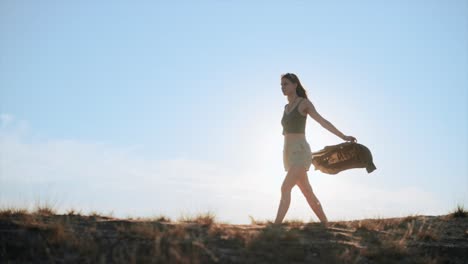 Intrepid-traveller,-woman-walking-in-desert-at-sunset,-cinematic-slow-motion