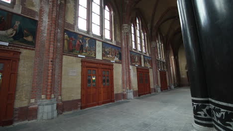 Wooden-Doors-With-Paintings-Above-Inside-The-Brick-Building-Of-Gouwekerk-Church-In-Gouda,-Netherlands