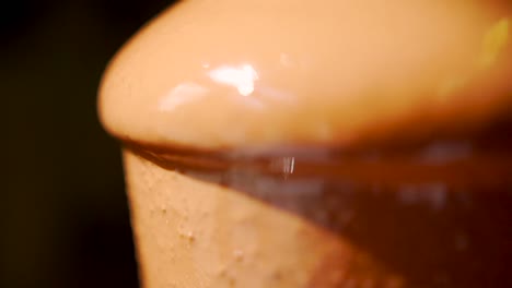 A-close-up-shot-of-hot-melted-chocolate-flows-down-the-fountain-cascade-sweet-hot-dessert-appetizingly-dripping-down-the-fountain