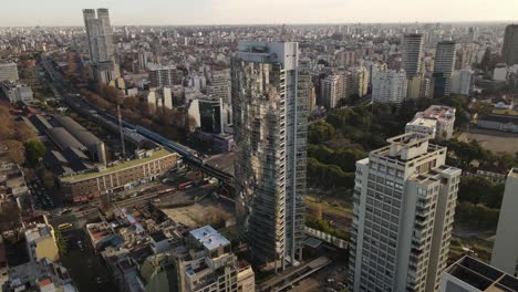 Luftflug-Des-Luxuriösen-Spiegelglas-Wolkenkratzers-Mit-Swimmingpool-Auf-Dem-Dach---Epische-Stadt-Buenos-Aires-Bei-Sonnenuntergang-Im-Hintergrund,-Argentinien