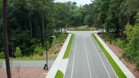 Opening-shot-among-forest-trees-above-side-leads-to-traffic-circle-and-landscaped-flower-bed