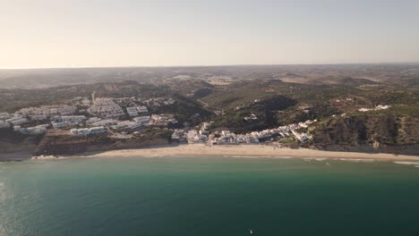 Dolly-in-aerial-view-of-a-small-beach-Praia-da-Salema-Algarve-Portugal