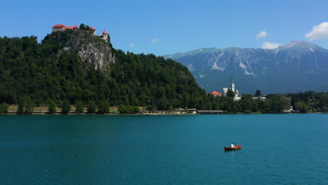 Fernsicht-Auf-Ein-Paar-Auf-Einem-Ruderboot-Am-Bleder-See-Mit-Bleder-Burgmuseum-Auf-Der-Klippe-In-Slowenien