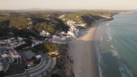 Panning-aerial-view-of-coastal-village-Praia-da-Salema-beach-in-Algarve-Portugal