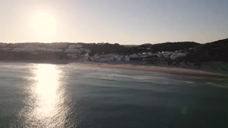 Sonne-Spiegelt-Sich-Im-Ozean-Wider,-Während-Sie-In-Richtung-Salema-Beach-In-Portugal-Fliegt