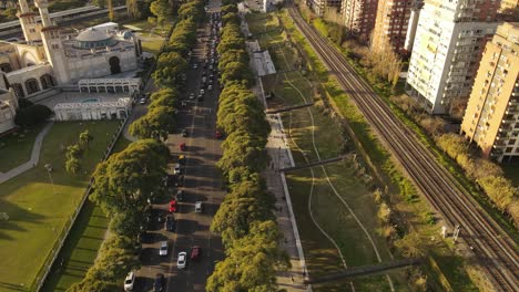 Aerial-flight-over-traffic-on-city-road-amidst-high-rise-buildings-in-Buenos-Aires,-Argentina