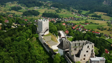 Vista-Aérea-De-Las-Antiguas-Ruinas-Del-Castillo-De-Celje-En-La-Cima-De-Verdes-Colinas-En-Celje,-Eslovenia