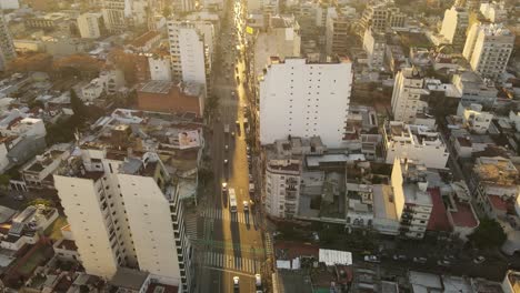 Aerial-drone-flight-over-frequented-avenue-in-Buenos-Aires-during-golden-sunset---Top-down-shot-of-central-district-with-high-buildings-and-skyscrapers