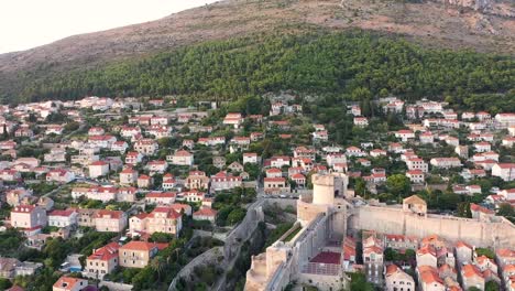 Aerial-shot-of-a-hill-above-the-great-town-Dubrovnik-with-a-stunning-view-at-sunset