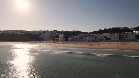 Gente-Disfrutando-De-Los-últimos-Rayos-De-Sol-Del-Día-En-La-Playa-De-Salema,-Portugal