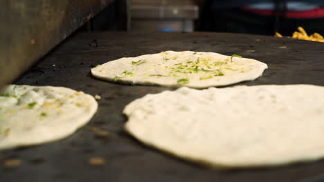 Naan-gets-toasted-on-hot-griddle-in-Indian-restaurant-kitchen,-steam-rises-from-hot-Indian-fratbread,-slow-motion-close-up-HD