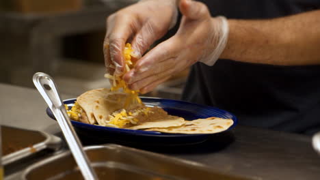 Cook-prepares-bean-and-cheese-tacos-in-Mexican-restaurant-kitchen,-slow-motion-HD