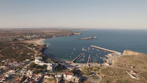 Steigende-Antenne-über-Einem-Kreisverkehr-Mit-Blick-Auf-Den-Hafen-Von-Sagres-In-Portugal