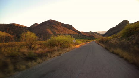 Conduciendo-Por-Una-Carretera-Rural-A-Través-De-Colinas-En-Arizona-Al-Amanecer