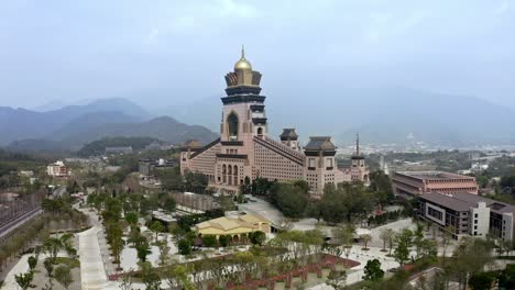 Luftbild,-Das-Den-Buddhistischen-Tempel-In-Der-Stadt-Puli,-Taiwan,-Mit-Einer-Wunderschönen-Bergkette-Im-Hintergrund-Zeigt