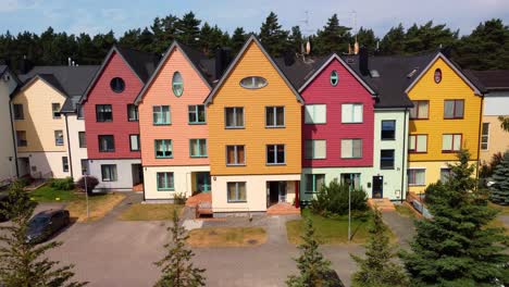 aerial-shot-of-the-colorful-joined-houses-near-the-forest,-tilt-down-shot