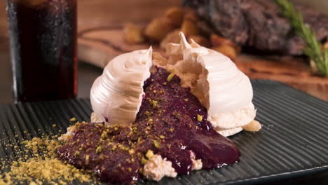 Classic-fine-dining-Pavlova-dessert-with-blackberry-coulis-spilling-out,-slider-slow-motion-HD