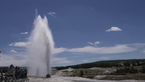 Crowds-of-people-give-a-sense-of-scale-as-they-watch-Old-Faithful-geyser-erupting-at-Yellowstone-Park,-Wyoming,-USA