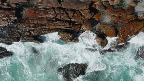 Macro-Of-Big-Ocean-Waves-Crashing-at-The-Rocky-Landscape-Of-The-Cliff-At-Cape-Town,-South-Africa