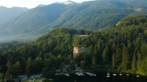 Grüner-Wald-Und-Werft-Am-Ufer-Des-Bohinj-Sees-Mit-Blick-Auf-Die-Bergkette-In-Slowenien
