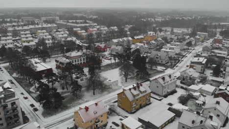 Aerial-Shot-Of-A-Nordic-City-During-Winter-In-Sweden,-Snow-Covered-Houses-And-Streets