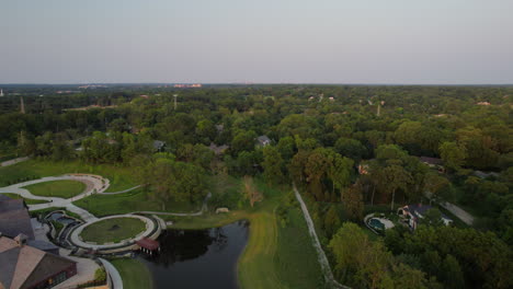 Aerial-descent-down-towards-a-pretty-park-with-a-pond-in-Town-and-Country-in-St
