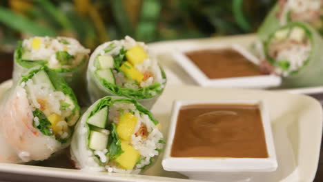 Colorful-stacked-rice-paper-rolls-with-peanut-sauce,-slider-slow-motion-4K
