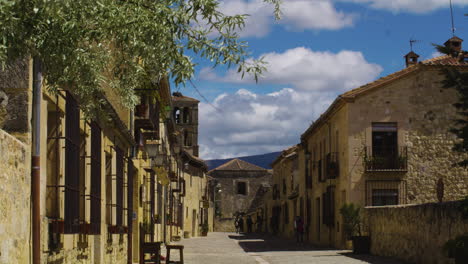 Turistas-Caminando-Por-La-Carretera-Rodeada-De-Edificios-Medievales-En-La-Ciudad-De-Pedraza-En-Segovia,-España