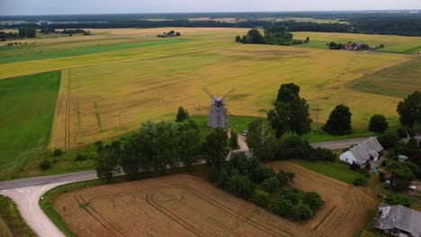 aerial-shot-of-an-old-windmill-in-the-field,-zooming-in