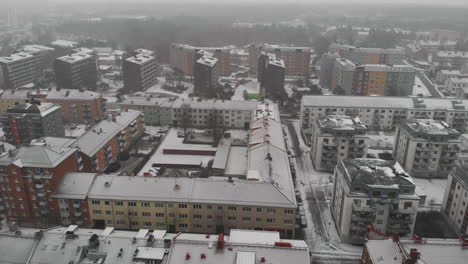 Aerial-view-of-a-snowy-winter-wonderland-landscape-of-a-town-in-Trollhättan,-Sweden
