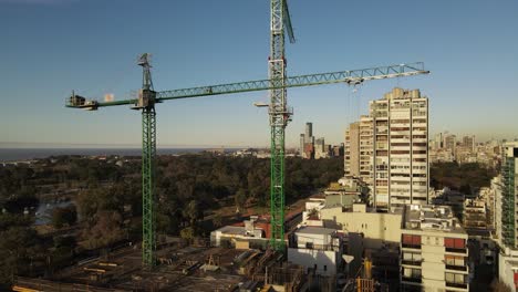 A-construction-crane-installed-at-the-top-of-a-building-under-construction-in-the-middle-of-an-urban-area