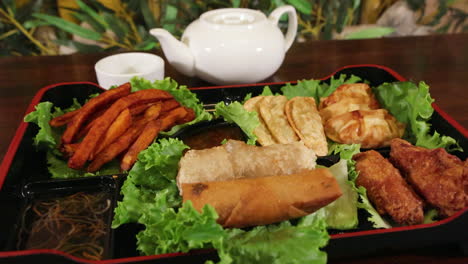 A-decadent-appetizer-platter-of-fried-asian-food,-slow-motion-slider-4K
