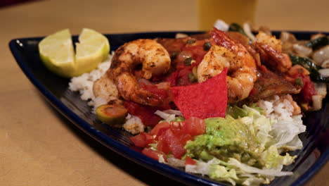 Grilled-shrimp-fajitas-over-rice-on-blue-triangle-plate,-slider-close-up-HD