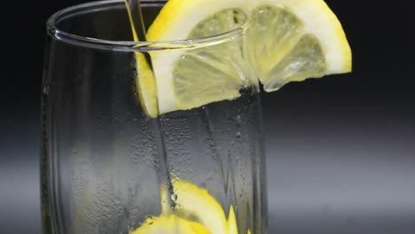 Pouring-Mineral-Water-into-a-glass-with-lemon-slices
