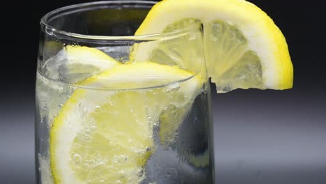Zitronenscheiben-In-Ein-Glas-Mit-Mineralwasser-Fallen-Lassen