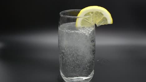 Mineralwasser-In-Ein-Glas-Gießen-Und-Eine-Zitronenscheibe-Hineingeben