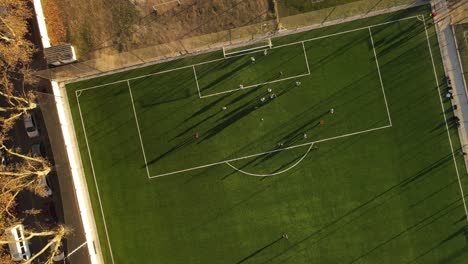 Luftaufnahme-Von-Oben-Nach-Unten-Von-Fußballspielern,-Die-Das-Spiel-Auf-Dem-Fußballplatz-Spielen