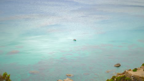 Distant-View-Of-Kayakers-In-Clear-Blue-Ocean-At-The-Beach-Of-Fomm-ir-Rih-In-The-Limits-Of-Mgarr,-Island-Of-Malta