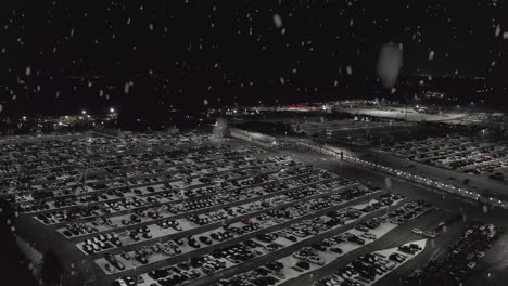 Snow-falls-on-huge-parking-lot-full-of-cars-in-winter