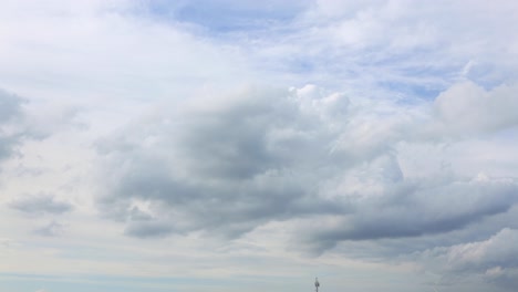 Ruhige-Wolkendecke,-Die-Sich-Bildet,-Und-Kleine-Kumuluswolken,-Die-Mit-Einem-Blauen-Himmel-Und-Sonnenstrahlen-Im-Hintergrund-Vorbeiziehen
