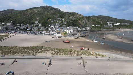 Barmouth-beach-with-tide-out-North-Wales,-UK-seaside-town-in-summer-aerial-footage