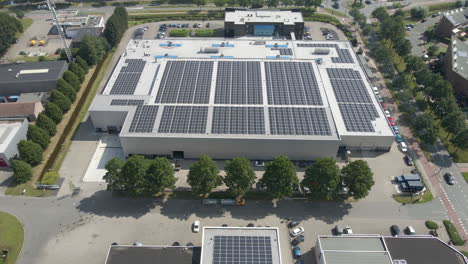 Drone-pulling-back-from-industrial-buildings-with-photovoltaic-solar-panels-on-rooftop