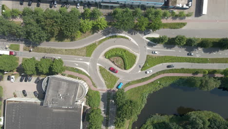Top-down-aerial-of-cars-driving-over-busy-intersection