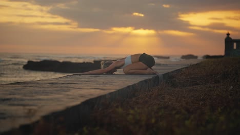 Frau,-Die-Während-Der-Yoga-Kind-Pose-Mit-Goldenem-Sonnenuntergang-Den-Kopf-Auf-Den-Boden-Senkt