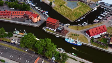Top-down-view-of-Port-of-Klaipeda-canal-with-sailing-boat-and-old-buildings---Lithuania