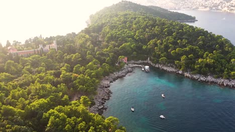 Aerial-view-of-the-coast-of-Lokrum-Island-and-boats-on-the-Adriatic-coastline-of-Croatia