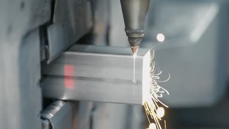 Tube-laser-cutter-is-cutting-through-a-stainless-steel-tube-with-flying-sparks