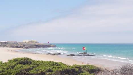 Ein-Wunderschöner-Sommertag-Am-Praia-Do-Guincho-Mit-Der-Portugiesischen-Flagge-Im-Vordergrund
