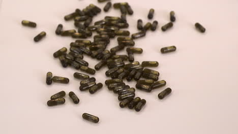 Brown-cannabis-oil-capsule-pills-are-poured-from-small-glass-bottle